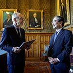 HE Judge Iwasawa Yuji offers HE Mr Luc Frieden a copy of the 80th anniversary book of the Court.